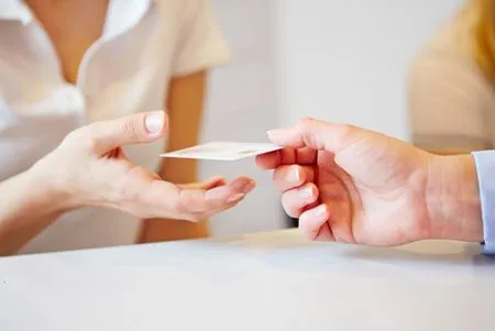 person handing a card to another person
